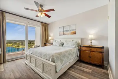 a bedroom with a bed with a ceiling fan and a window at The Beach Is Calling at Laketown Wharf #1329 at Nautical Properties in Panama City Beach