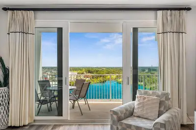 a living room with sliding glass doors to a patio at The Beach Is Calling at Laketown Wharf #1329 at Nautical Properties in Panama City Beach