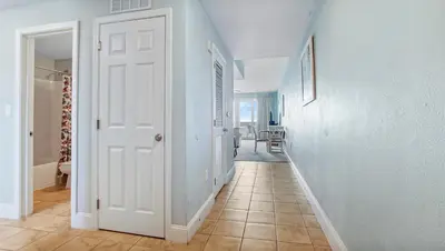 a hallway with a white door and a tile floor at Nautical Breeze at Laketown Wharf #1911 by Nautical Properties in Panama City Beach