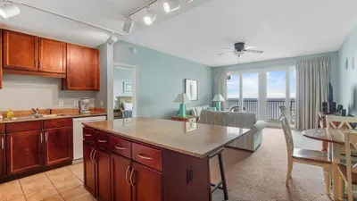 a kitchen and living room with a table and a dining room at Nautical Breeze at Laketown Wharf #1911 by Nautical Properties in Panama City Beach