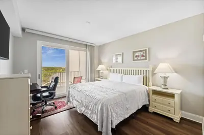 a bedroom with a bed and a desk and a window at Laketown Wharf #638 by Nautical Properties in Panama City Beach