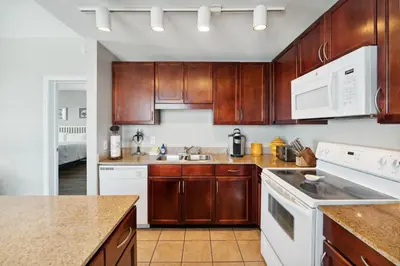 a kitchen with wooden cabinets and white appliances at Laketown Wharf #638 by Nautical Properties in Panama City Beach