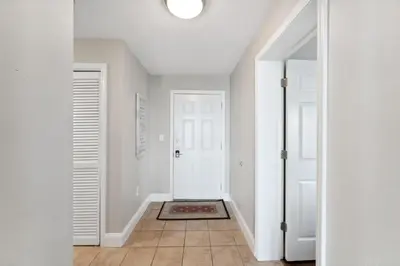 a hallway with a white door and a tile floor at Laketown Wharf #638 by Nautical Properties in Panama City Beach