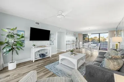 a living room with a couch and a tv at Moondrifter #208 by Nautical Properties in Panama City Beach