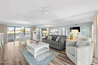 a living room with a couch and a table at Moondrifter #208 by Nautical Properties in Panama City Beach