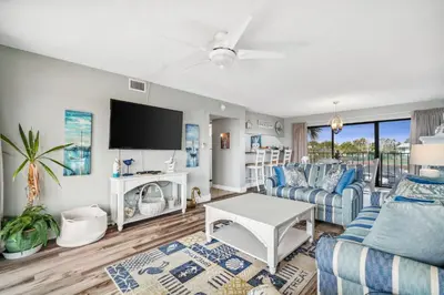 a living room with a couch and a tv at Moondrifter #208 by Nautical Properties in Panama City Beach
