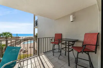 a balcony with a table and chairs and a view of the ocean at Moondrifter #307 by Nautical Properties in Panama City Beach