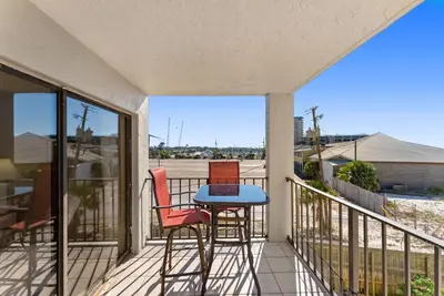 a balcony with two chairs and a table on it at Moondrifter #307 by Nautical Properties in Panama City Beach