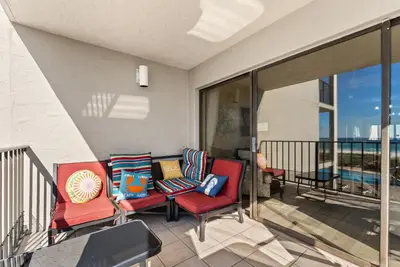 a balcony with two chairs and a table at Moondrifter #307 by Nautical Properties in Panama City Beach