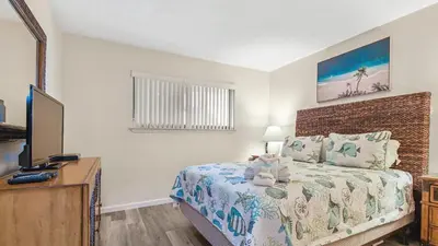 a bedroom with a bed and a desk with a television at Nautical Watch #D4 by Nautical Properties in Panama City Beach