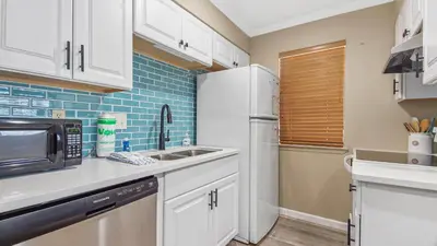 a kitchen with a white refrigerator and a sink at Nautical Watch #D4 by Nautical Properties in Panama City Beach