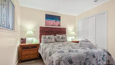 a bedroom with a bed and two lamps and a window at Nautical Watch #D4 by Nautical Properties in Panama City Beach