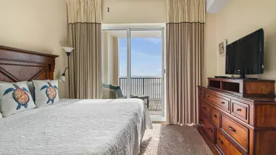 a bedroom with a bed and a flat screen tv at Ocean Reef #2109 by Nautical Properties in Panama City Beach