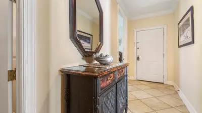 a hallway with a mirror and an old wooden dresser at Ocean Reef #2109 by Nautical Properties in Panama City Beach