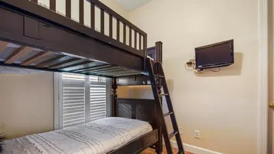 a bedroom with two bunk beds and a flat screen tv at Ocean Reef #2109 by Nautical Properties in Panama City Beach