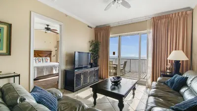 a living room with a couch and a television and a bed at Ocean Reef #2109 by Nautical Properties in Panama City Beach
