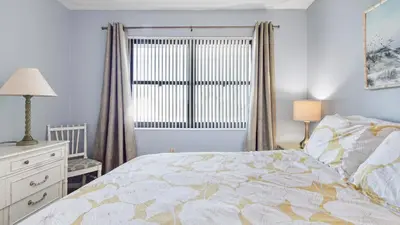 a bedroom with a bed and a dresser and a window at Sea Side Villas 118 by InJoy Vacations in Panama City Beach