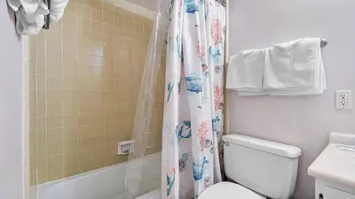a bathroom with a toilet and a shower curtain at Sea Side Villas 118 by InJoy Vacations in Panama City Beach