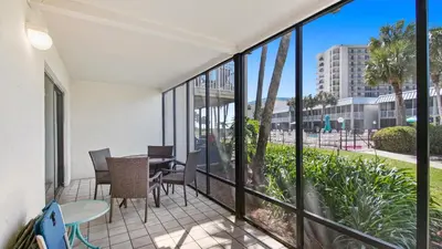 a balcony with a table and chairs and windows at Sea Side Villas 118 by InJoy Vacations in Panama City Beach