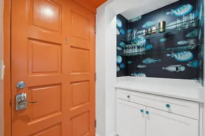 an orange door in a bathroom with a wall of alcohol at Sea Side Villas 118 by InJoy Vacations in Panama City Beach