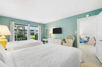 a large bedroom with two beds and a tv at Sea Side Villas 118 by InJoy Vacations in Panama City Beach