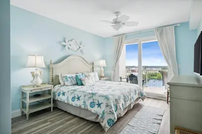 a blue bedroom with a bed and a window at Laketown Wharf #828 by Nautical Properties in Panama City Beach