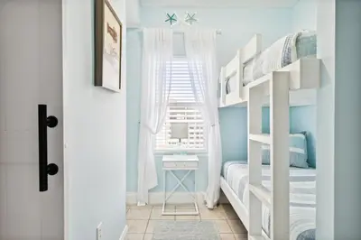 a bedroom with bunk beds with a desk and a window at Laketown Wharf #828 by Nautical Properties in Panama City Beach