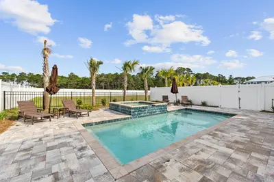 a swimming pool with patio furniture and a fence at Beach House - Sugary Sands by Panhandle Getaways in Panama City Beach