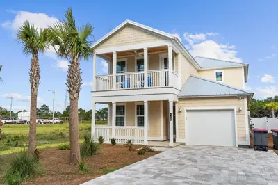 a house with a white garage and palm trees at Beach House - Sugary Sands by Panhandle Getaways in Panama City Beach