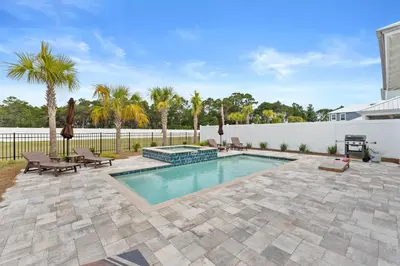 a swimming pool with a patio and a fence at Beach House - Sugary Sands by Panhandle Getaways in Panama City Beach