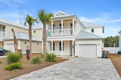 a white house with palm trees and a driveway at Pet Friendly Beach House - Sugary Sands by Panhandle Getaways in Panama City Beach