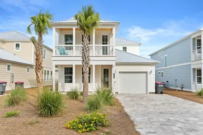 a house with a palm tree and a garage at Pet Friendly Beach House - Sugary Sands by Panhandle Getaways in Panama City Beach