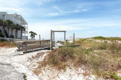 a wooden bench on the beach next to a building at Beachside Villas 933 in Santa Rosa Beach