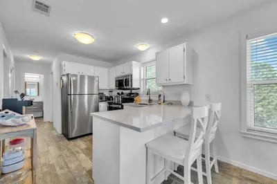 a kitchen with white cabinets and a stainless steel refrigerator at Beachside Villas 933 in Santa Rosa Beach