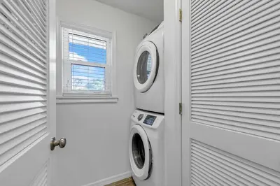 a white laundry room with a washing machine next to a door at Beachside Villas 933 in Santa Rosa Beach