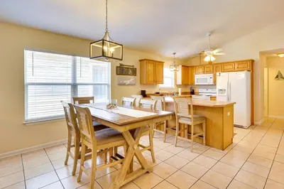 a kitchen and dining room with a wooden table and chairs at Panama City Vacation Rental with 2 Community Pools! in Panama City Beach