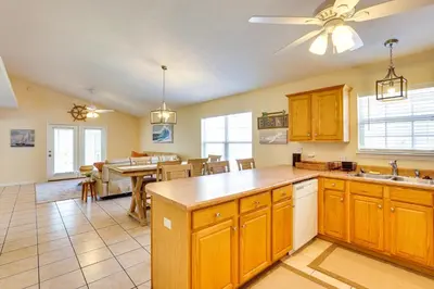 a kitchen with wooden cabinets and a dining room at Panama City Vacation Rental with 2 Community Pools! in Panama City Beach