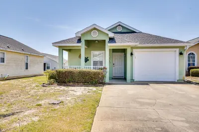 a green house with a white garage at Panama City Vacation Rental with 2 Community Pools! in Panama City Beach