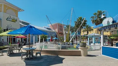 a street with tables and umbrellas in a town at A Salty Cru in Panama City Beach