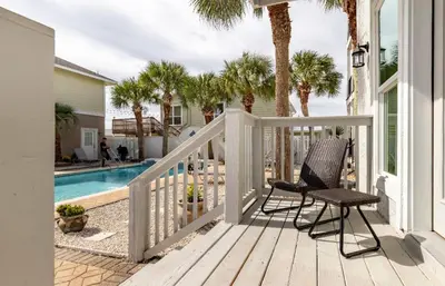 a porch with two chairs and a swimming pool at Sea La Vie in Panama City Beach