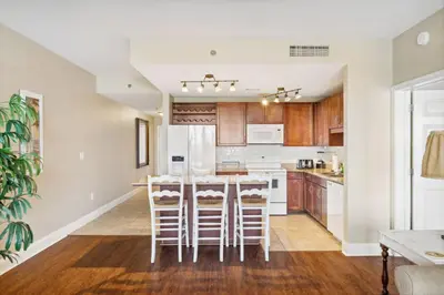 an open kitchen with a table and stools at Laketown Wharf #1230 by Nautical Properties Vacation Rentals in Panama City Beach