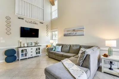 a living room with a couch and a tv at Walk to Beach! PCB Resort Condo with Pool Access in Panama City Beach
