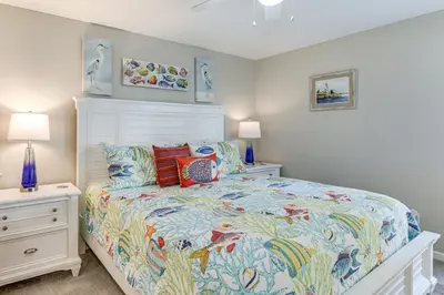 a bedroom with a large bed with a colorful comforter at Walk to Beach! PCB Resort Condo with Pool Access in Panama City Beach