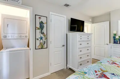 a bedroom with a bed and a dresser and a tv at Walk to Beach! PCB Resort Condo with Pool Access in Panama City Beach