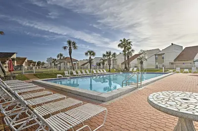 a swimming pool with lounge chairs and a table at Walk to Beach! PCB Resort Condo with Pool Access in Panama City Beach