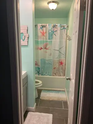 a bathroom with a shower curtain and a toilet at Beach access close to Walmart, Bowling,skating and Game room in Panama City Beach