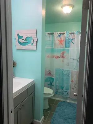 a bathroom with a toilet and a shower curtain at Beach access close to Walmart, Bowling,skating and Game room in Panama City Beach