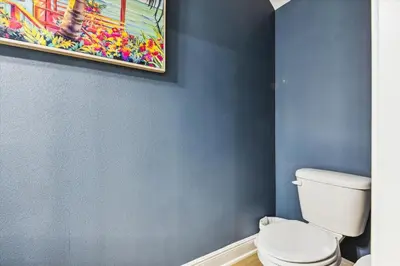 a bathroom with a toilet and a painting on the wall at 7664 Shadow Lake - Happy Horizons - 3 Bedroom Sleeps 9 townhouse in Panama City Beach