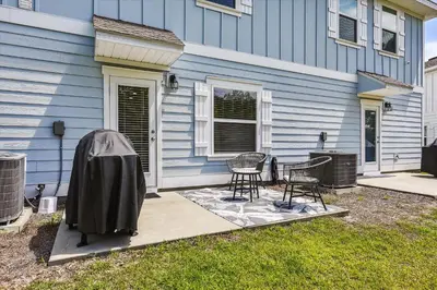a house with a table and chairs in front of it at 7664 Shadow Lake - Happy Horizons - 3 Bedroom Sleeps 9 townhouse in Panama City Beach