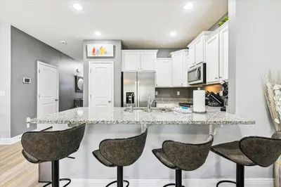a kitchen with a large island with four bar stools at 7664 Shadow Lake - Happy Horizons - 3 Bedroom Sleeps 9 townhouse in Panama City Beach